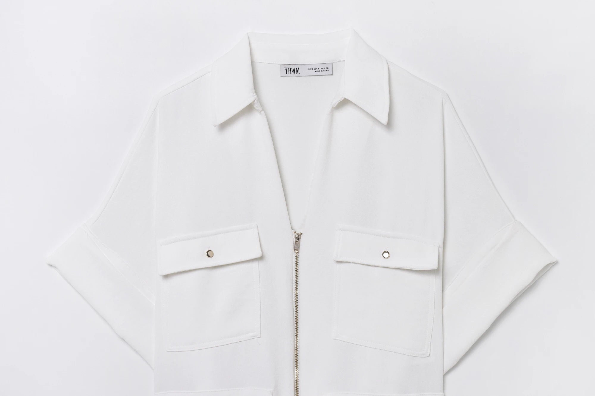Dettaglio camicia bianca - zip frontale argento e tasche con bottone metallico